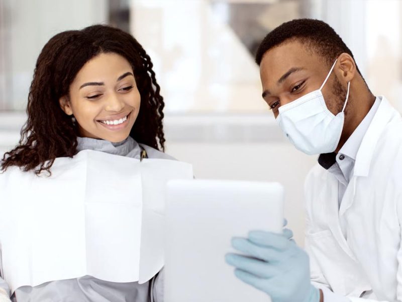 Patient using a mirror to look at the dental results in a dental clinic